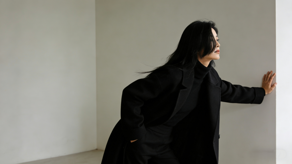 Edgy yet refined winter look: Black wool overcoat, slim black turtleneck, and tailored black trousers – timeless monochromatic minimalist ensemble